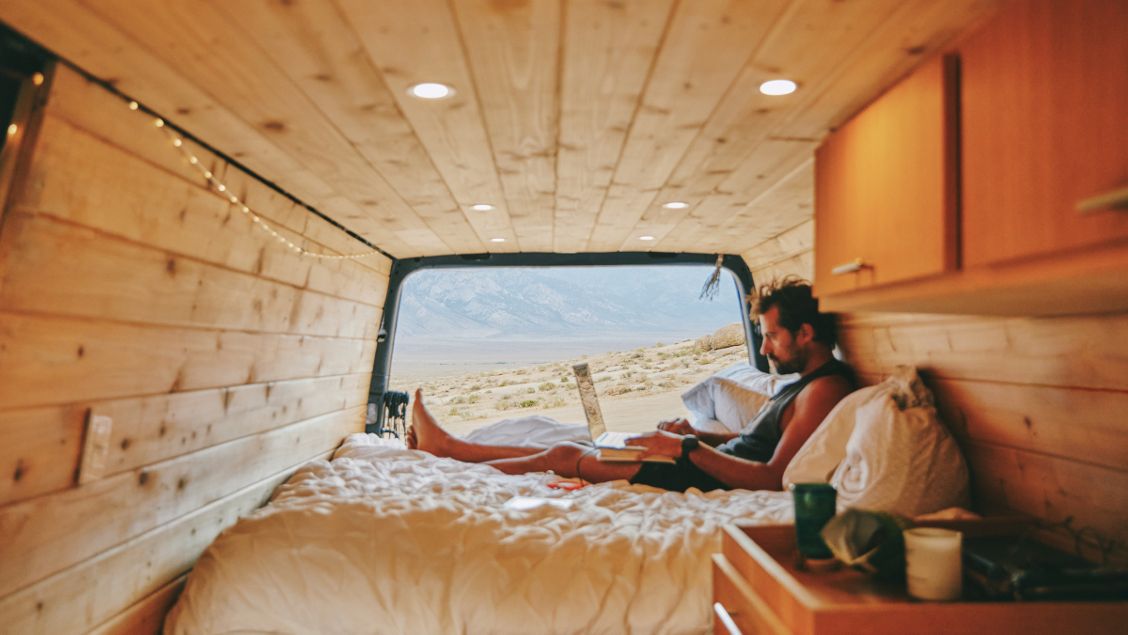 Digital nomad in camper aan het werk op laptop
