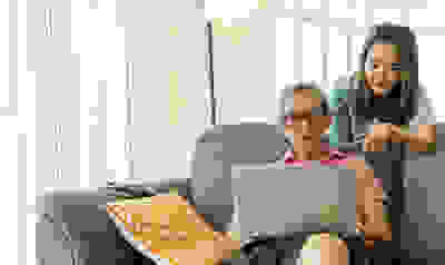 Meisje helpt opa met laptop