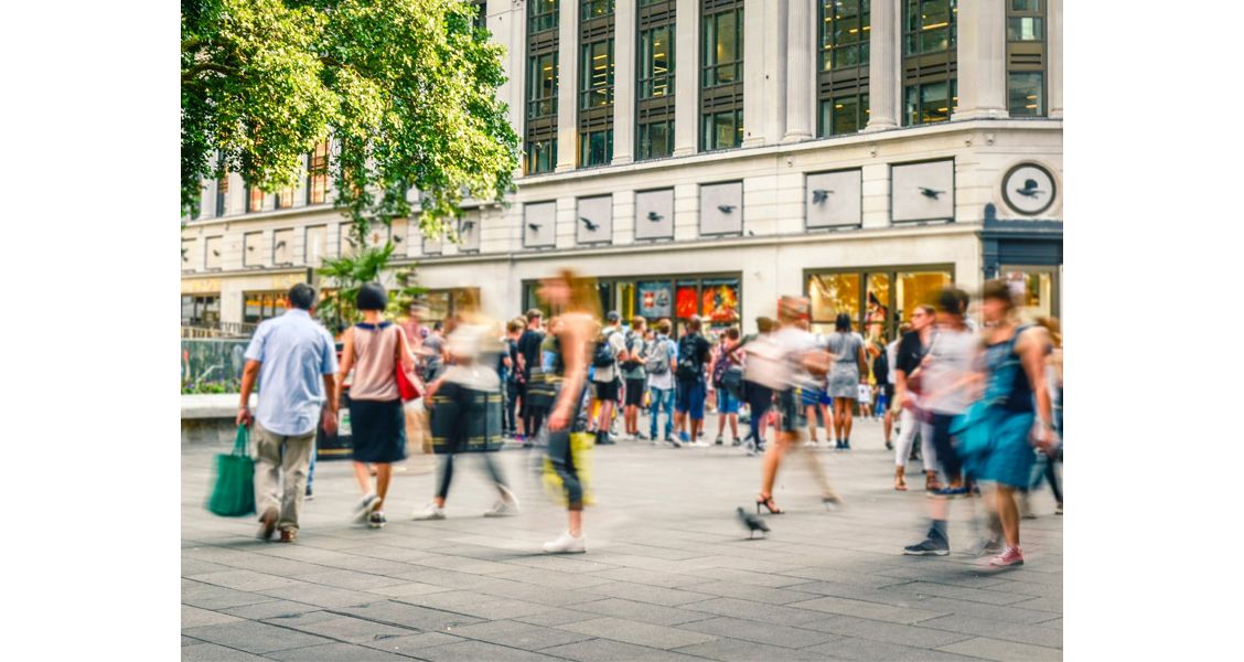 Een volle winkelstraat met winkelende mensen
