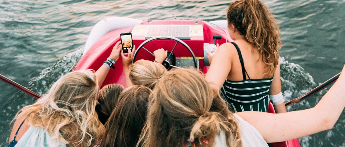 Een groepje meiden maakt een selfie in een boot